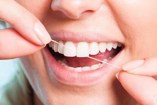 woman flossing before visiting our darwin dental office