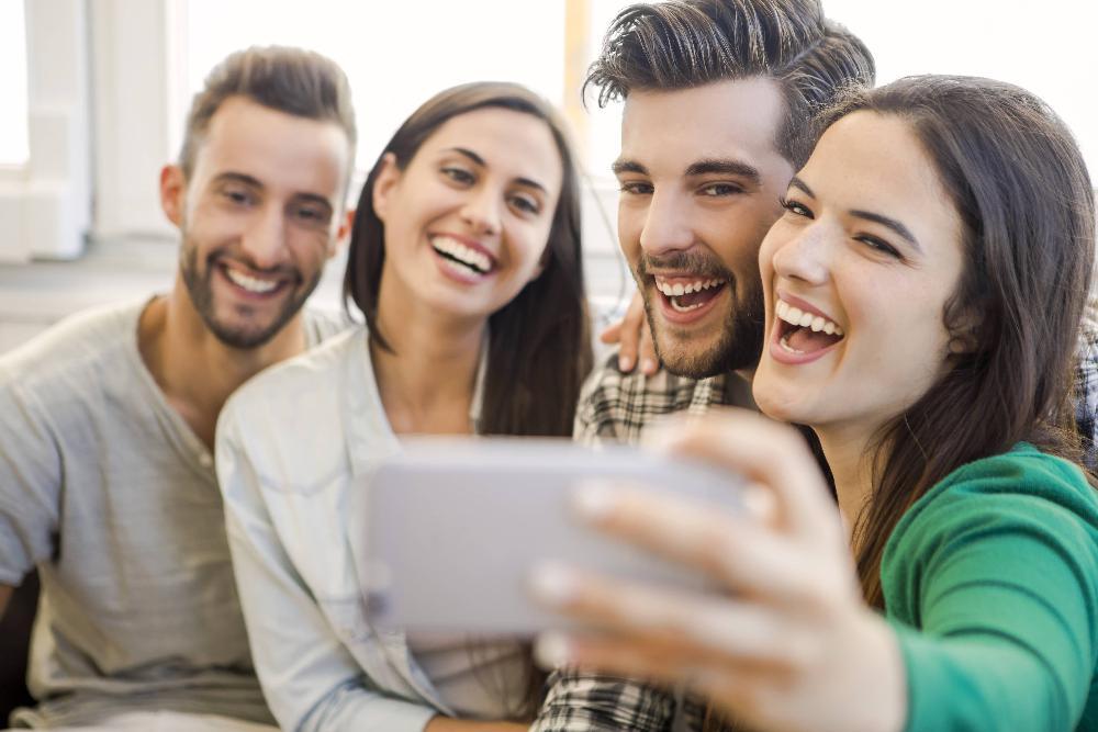 group of four friends taking a selfie