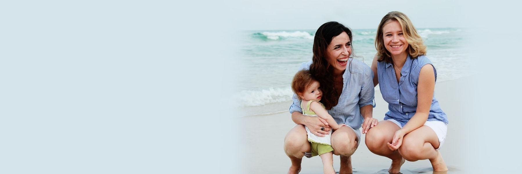 Two young women & baby on a beach l Family dentist in Casuarina NT