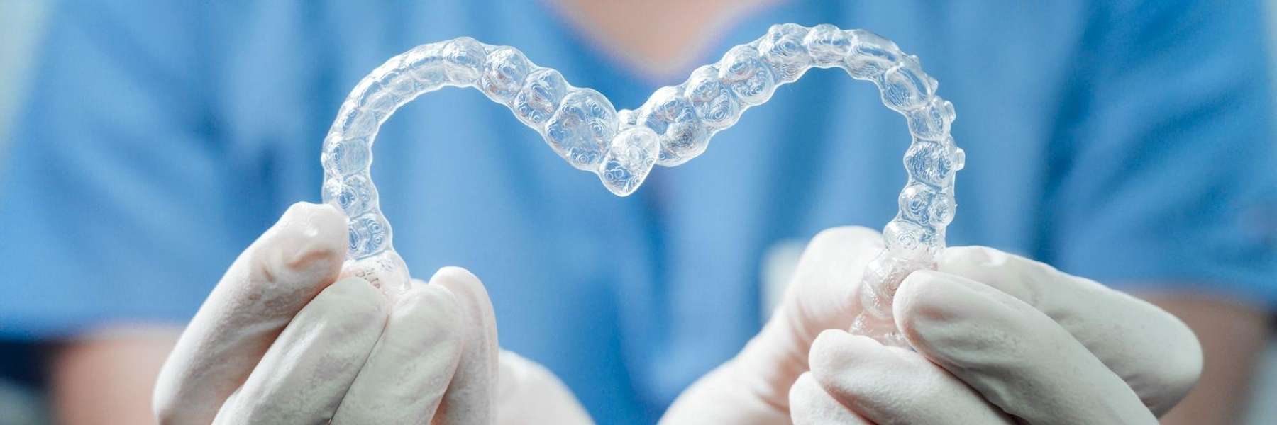 A doctor holding a pair of Invisalign® in Casuarina, NT