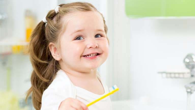 young girl holding tooth brush