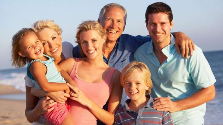 multigenerational family smiling on beach