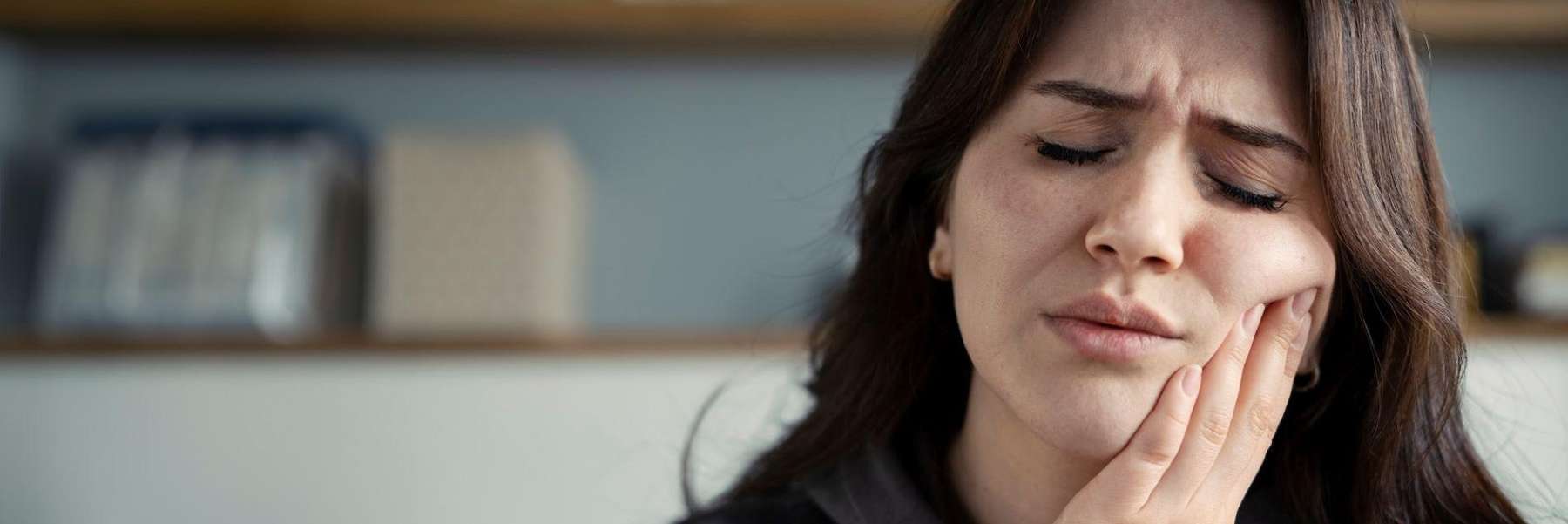 woman holding jaw from pain during an emergency