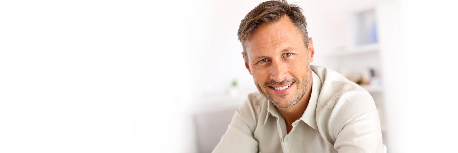 Man with facial hair smiling after getting a cerec crown