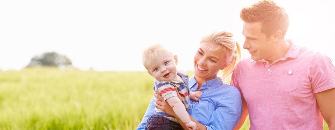 a young family smiles in a meadow in darwin
